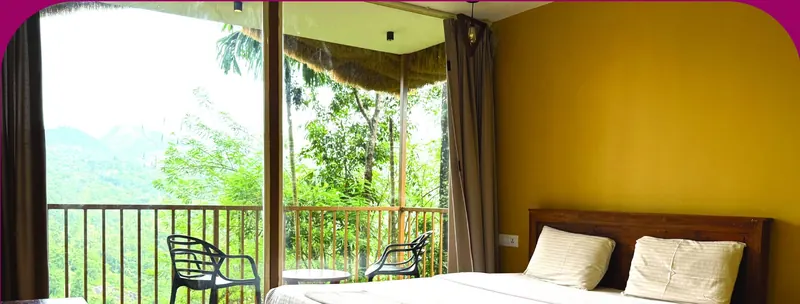 Bamboo Hut bedroom opening onto a balcony with mountain views
