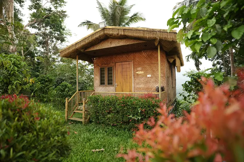 Thatched bamboo hut with wooden deck at Purayil Resort