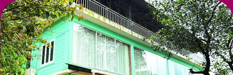 Capsule Villa building with large glass windows among the trees