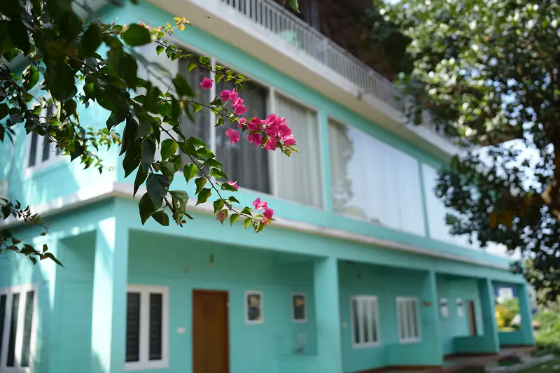 Turquoise facade of the Capsule Villa with bougainvillea