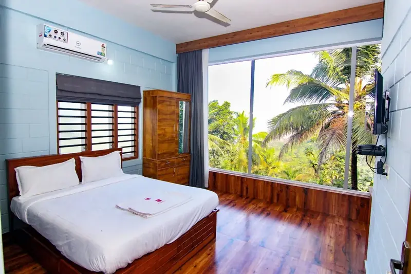 First floor Capsule Villa bedroom with a large window view of palms