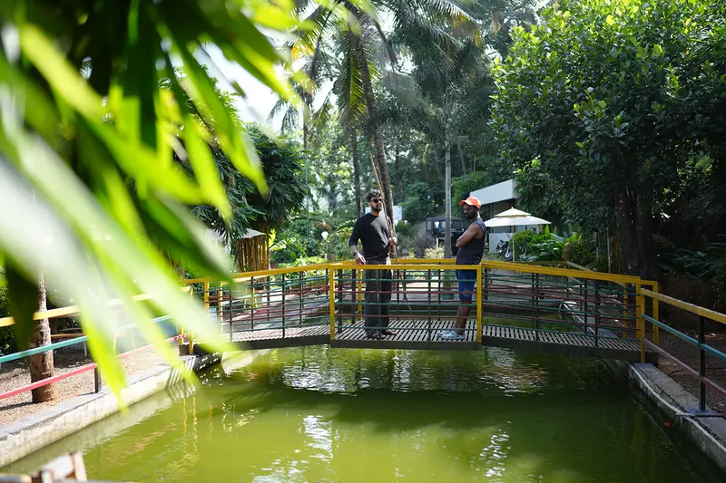 Guests on the bridge over the live fishing pond at Purayil Resort