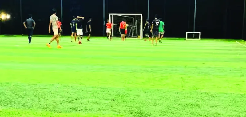 Friends playing football on the floodlit turf at Purayil Resort