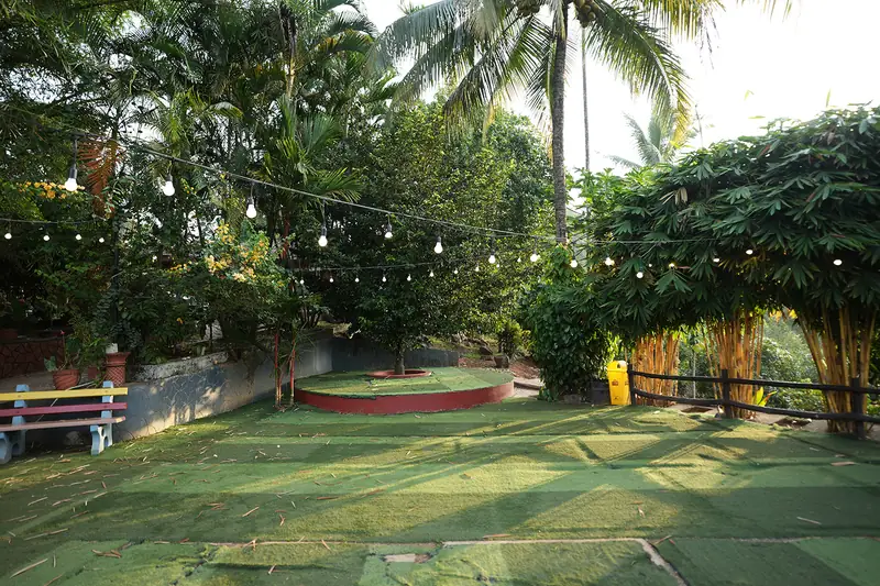 Garden lawn with string lights and a round stage at Purayil Resort