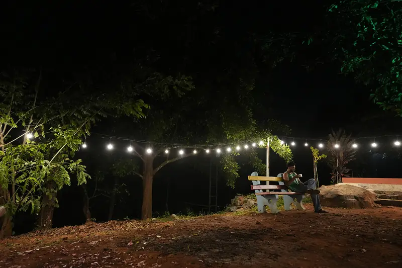 Gardens glowing with string lights at night at Purayil Resort
