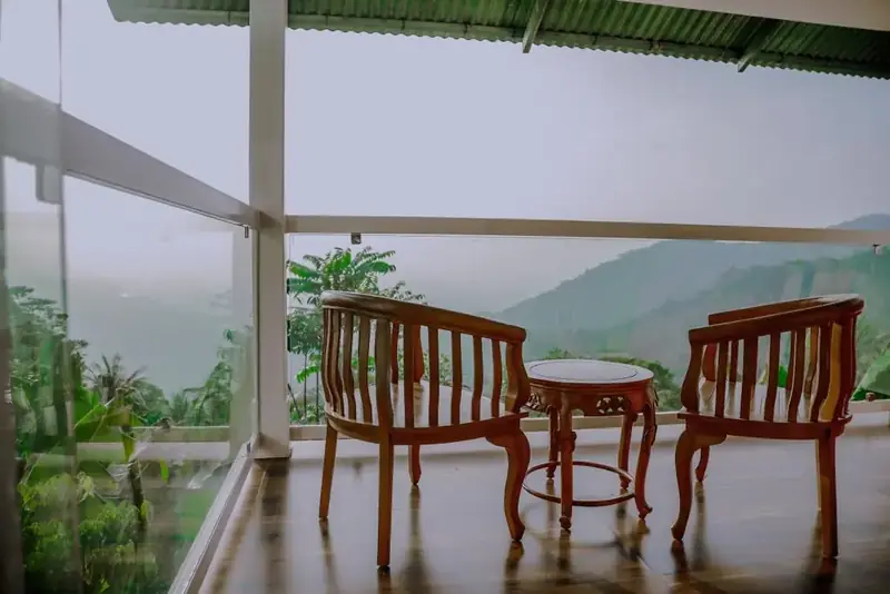 Glass-walled balcony of Lavista Villa overlooking misty hills