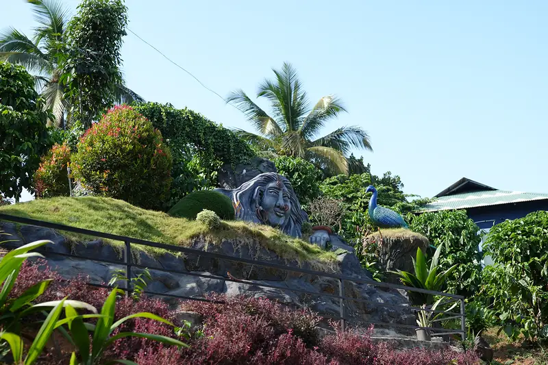 Sculpture garden with peacock figure and landscaped hillside